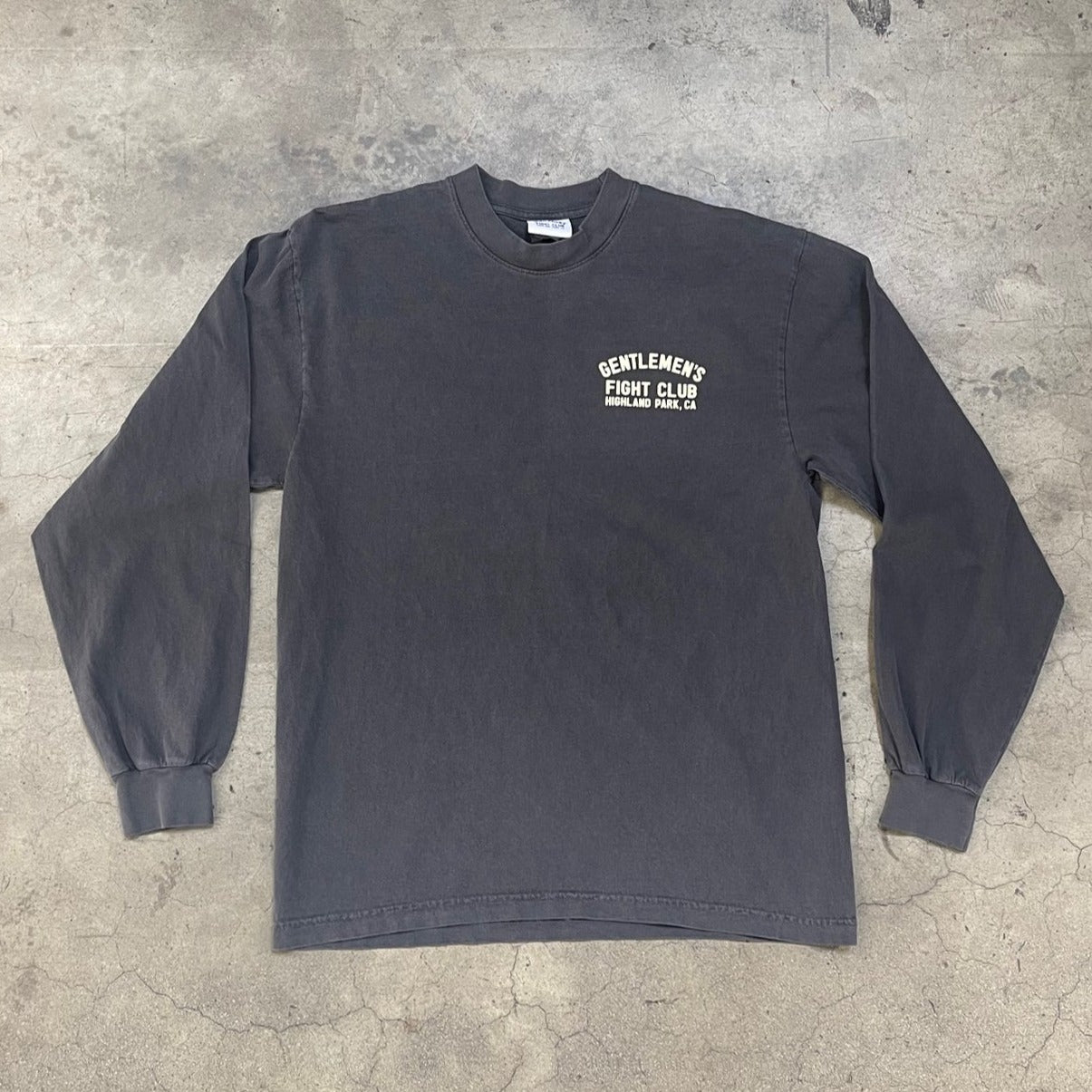 Front of long sleeve faded black shirt. Cream colored graphic print reads "Gentlemen's Fight Club Highland Park, CA"